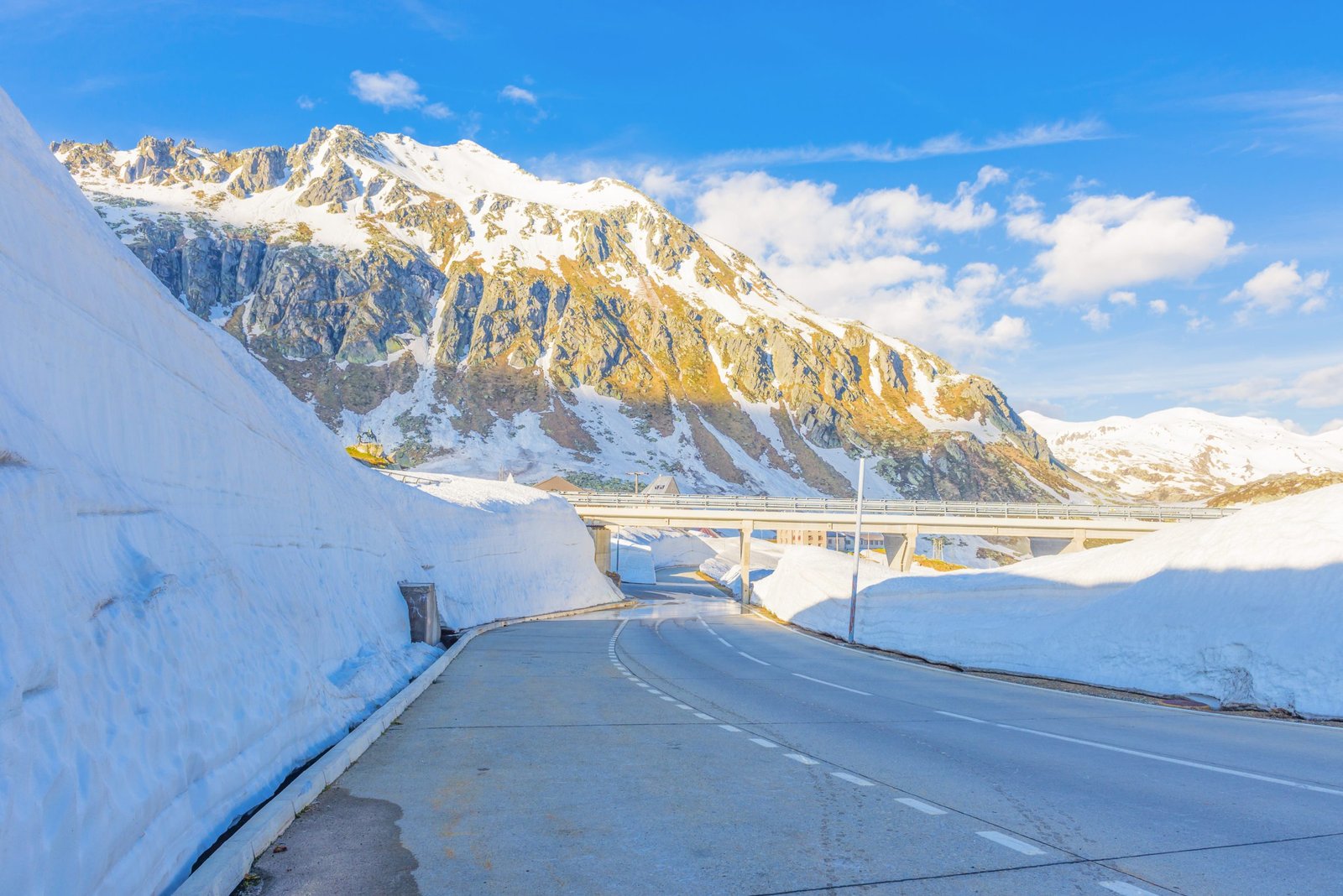 The Gotthard Pass surrounded by mountains covered in the snow under the sunlight in Switzerland